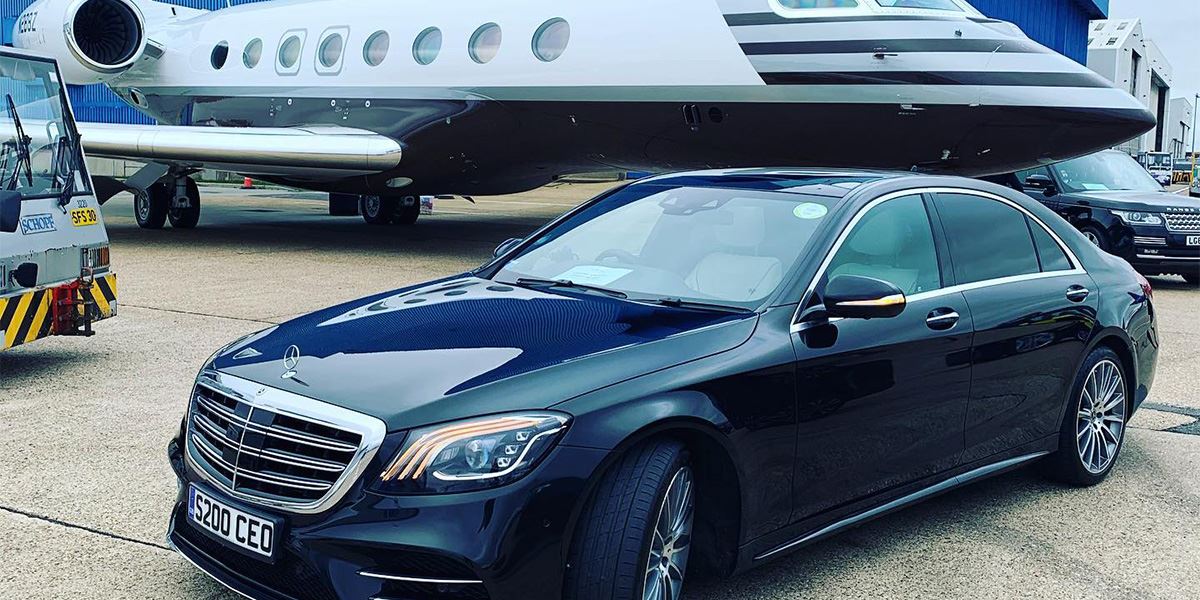 A Jonny-Rocks luxury Mercedes-Benze S-Class saloon stands in front of a private jet