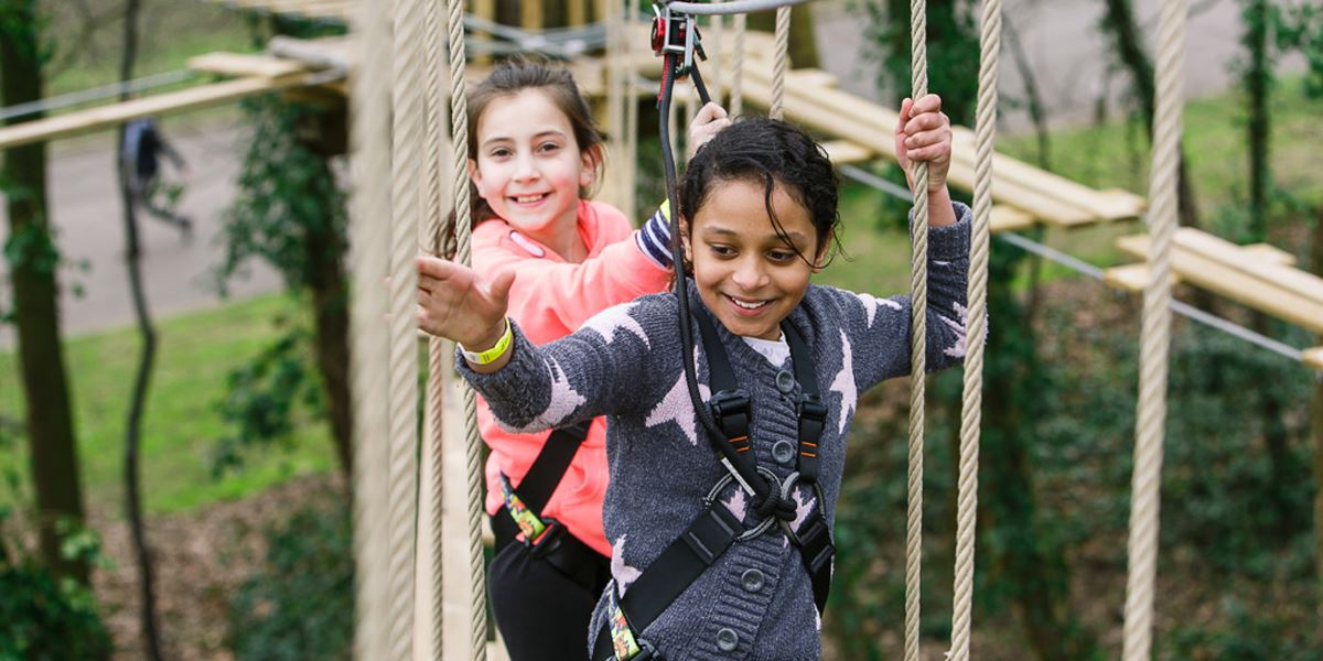 Two girls crossing the rope ladders at Go Ape