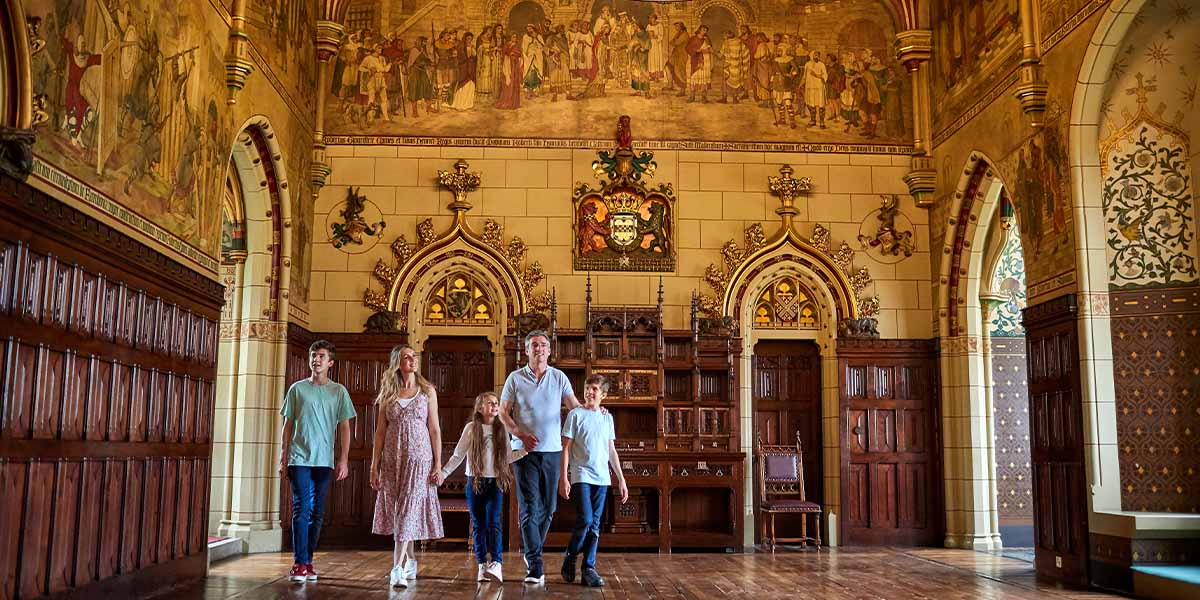 A family walks through a fabulous hall of Cardiff Castle