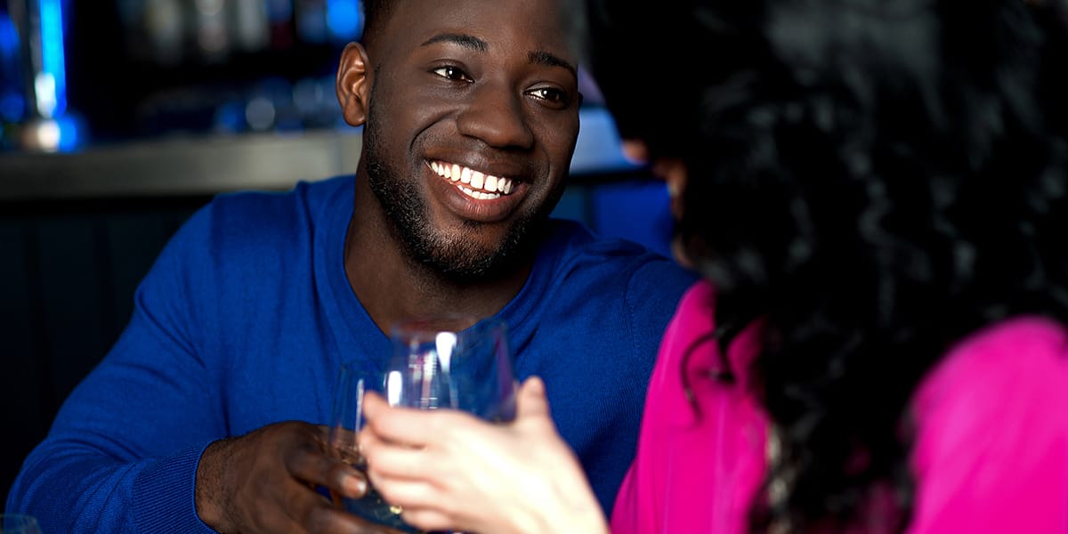 Image of two people having a drink at a bar